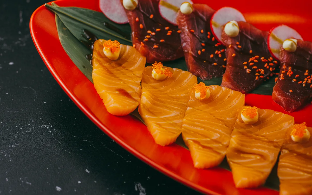 Sashimi mixto: cortes de salmón y atún servidos con wasabi y jengibre